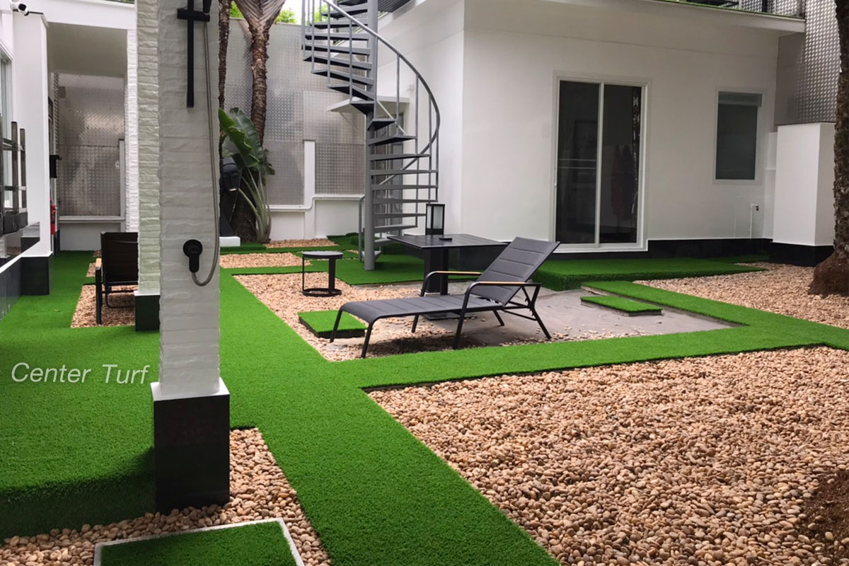 ตกแต่งทางเดินด้วยหญ้าเทียม สลับสวนหินสีน้ำตาลอ่อน เข้ากันได้ดีและลงตัว